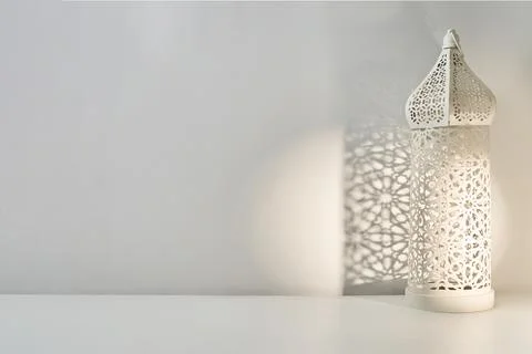 White ramadan lantern casting islamic pattern shadow on wall Stock Photos