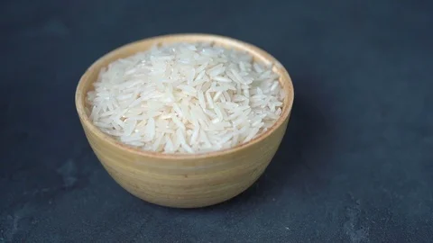 White raw basmati rice in bamboo bowl on dark concrete background. Stock Footage 123570834