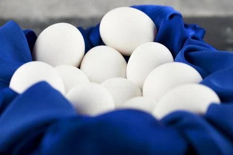 White raw chicken eggs with on a blue tablecloth Stock Photos