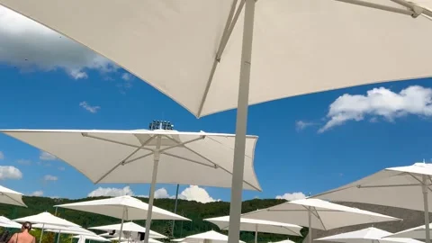 White rectangular beach umbrellas in a poolside seating area. Stock Footage 318973111
