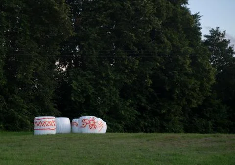 White, rectangular boxes with red patterns situated outdoors in a field against Stock Photos