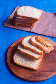 White rectangular bread lies on a blue wooden background Stock Photos