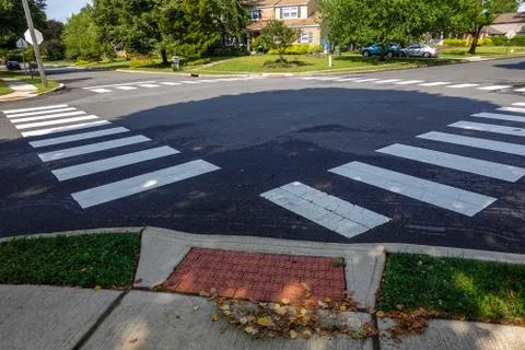 White rectangular intermittent crosswalk markers painted on the asphalt road  Stock Photos