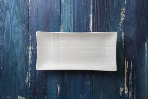 White rectangular Plate on blue wooden background Stock Photos