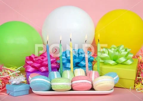 White rectangular plate with pastel colored macaron cookies laying on a pink Stock Photos