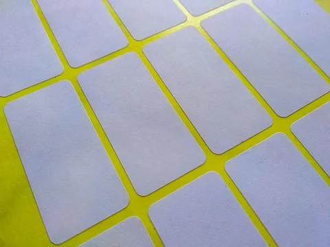 White rectangular price tag stickers on a bright yellow background sheet Foto stock