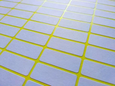 White rectangular price tag stickers on a bright yellow background sheet Stock-Fotos