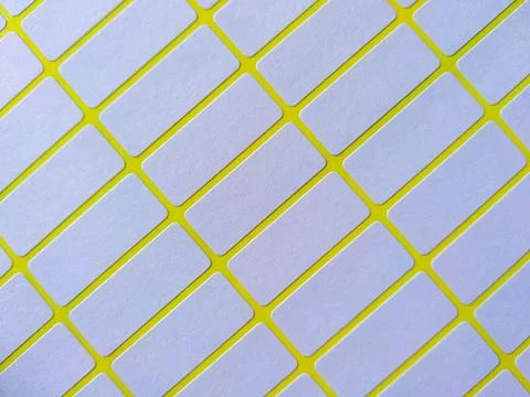 White rectangular price tag stickers on a bright yellow background sheet Foto stock
