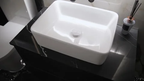 White rectangular sink on black marble countertop in bathroom interior 库存影片 307908448