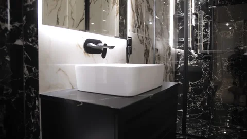 White rectangular sink on black vanity in marble bathroom Stock Footage 307908126