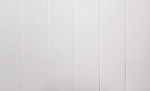White rectangular subway tile wall surface with clean grout lines. Smooth Stock Photos