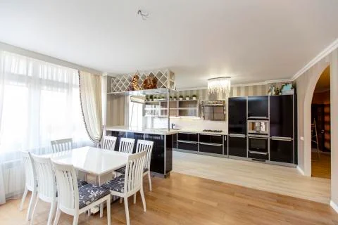 White rectangular table with white high-backed chairs in the kitchen-living r Stock Photos