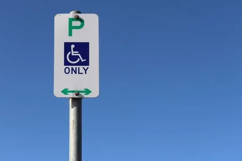 White rectangular wheelchair car parking sign isolated on a blue background 스톡 사진