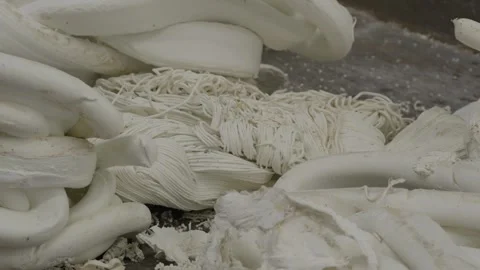 White recycled plastic extruded strips and threads on factory floor Stock Footage 334167307