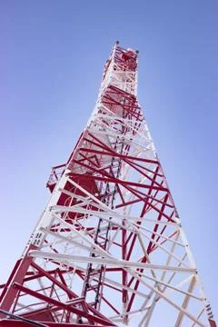 White-red cell tower or mobile tower on blue sky shot from bottom Stock Photos