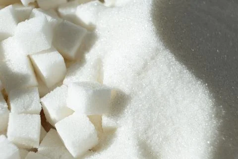 White refined beet sugar in the form of crystals and cubes. Stock Photos
