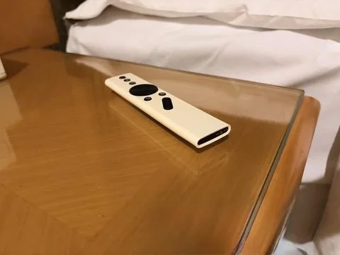 White Remote Control on Wooden Bedside Table Stock Photos