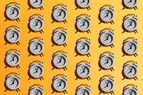 White retro alarm clock pattern on orange yellow background. Creative minimal Stock Photos