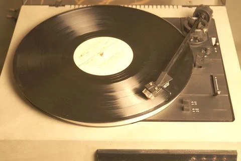 White retro record player on a gray table. Selective focus. Stock Photos