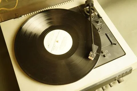 White retro record player on a gray table. Selective focus. Stock Photos