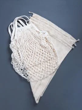 The white reusable string bags for different products on the grey background. Stock Photos