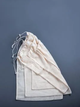 The white reusable string bags for different products on the gray background. Stock Photos