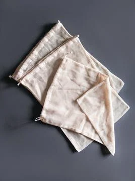 The white reusable string bags for different products on the gray background. Stock Photos