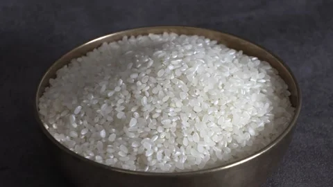 White rice in a brassware on a black background. Stock Footage 303397328