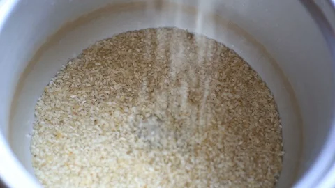 White rice falling in to container. Video stock 129532200