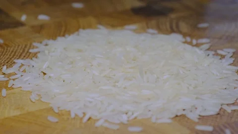 White Rice Grains Falling Slowly on a Rice Pile on a Wooden Board Stock Footage 126829031