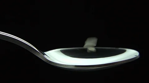White rise, falling down into a spoon Slow Motion Stock Footage 83038263