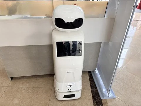 White robot standing in a hallway. Stock Photos