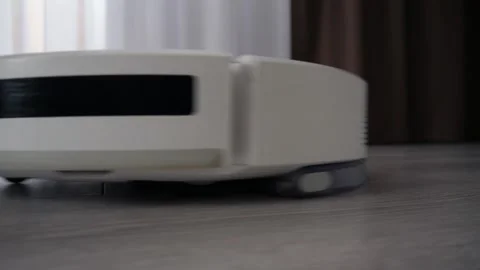 White robot vacuum cleaner cleaning the floor in the apartment Stock Footage 306543156
