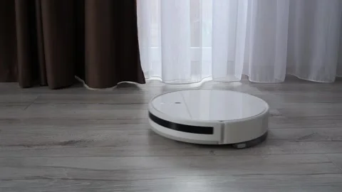 White robot vacuum cleaner cleaning the floor in the apartment Stock Footage 306780635