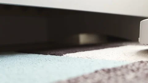 A white robot vacuum cleaner cleans a carpeted room. Stock Footage 166035910