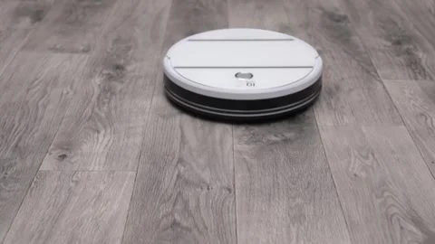 White robot vacuum cleaner cleans the gray floor Stock-Footage 240456083