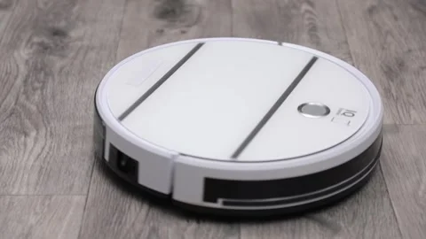 White robot vacuum cleaner cleans the gray floor 스톡 동영상 241951546