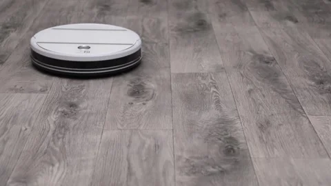 White robot vacuum cleaner cleans the gray floor Video stock 243444858