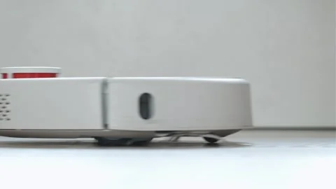 White robot vacuum cleaner cleans the floor from debris Stock Footage 250194867