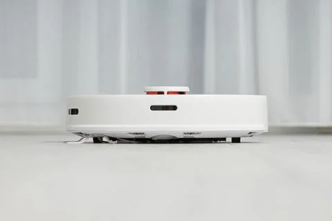 White robot vacuum cleaner effectively cleans the floor Foto stock
