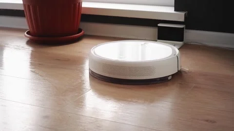White robot vacuum cleaner returning to charging station Stock Footage 303353693