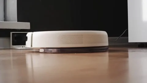 White robot vacuum cleaner returning to charging station Video stock 303353823