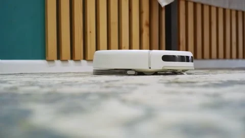 White robot vacuum cleaner working on carpet Stock Footage 303353941