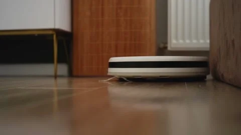 White robot vacuum cleaner working on wooden floor Video stock 303484205