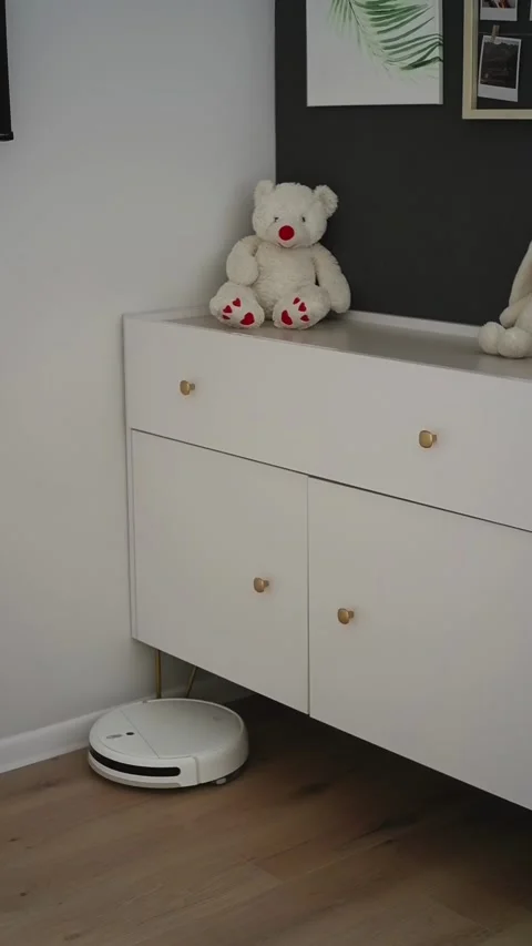 White robot vacuum cleaner working in modern living room Stock Footage 303484553