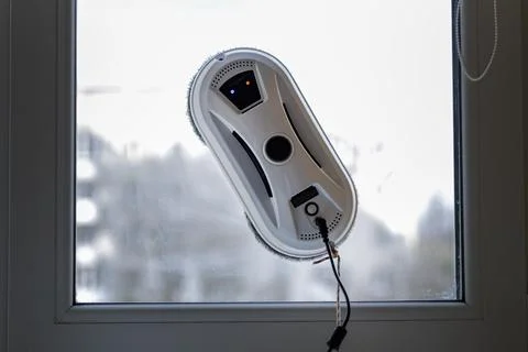 White Robotic Window Cleaner in Action on Dirty Glass Pane Stock Photos