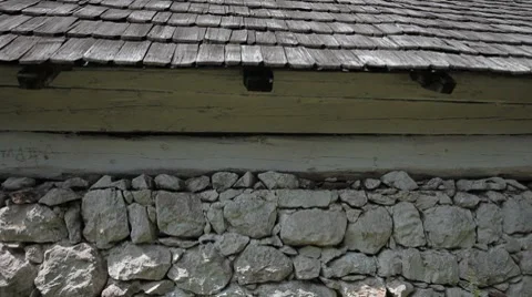 White rock external wall of house  supporting wooden roof with large beam HD Stock Footage 7733746