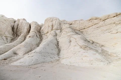 White rock formations with layered textures in a desert landscape Stock Photos