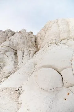 White rock formations with textured surface against a cloudy sky Stock Photos