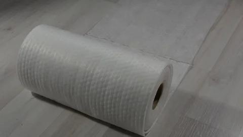 A white roll of paper towels rolls out onto a bright floor Stock Footage 123714223